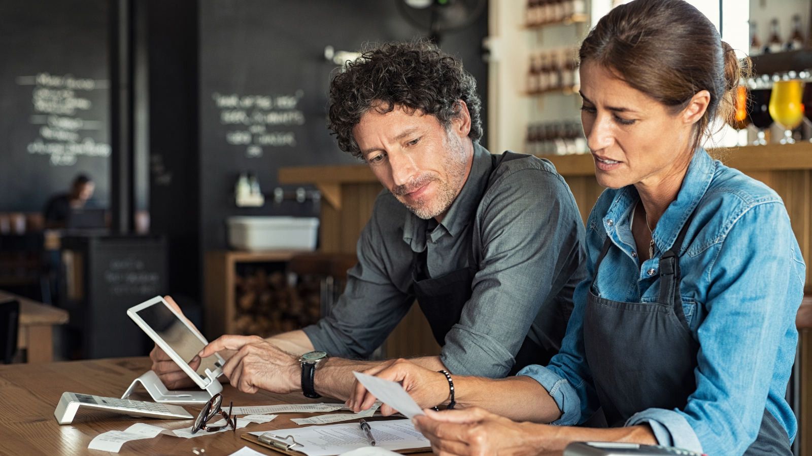 Small business owners reviewing receipts and expenses together while managing their business finances.